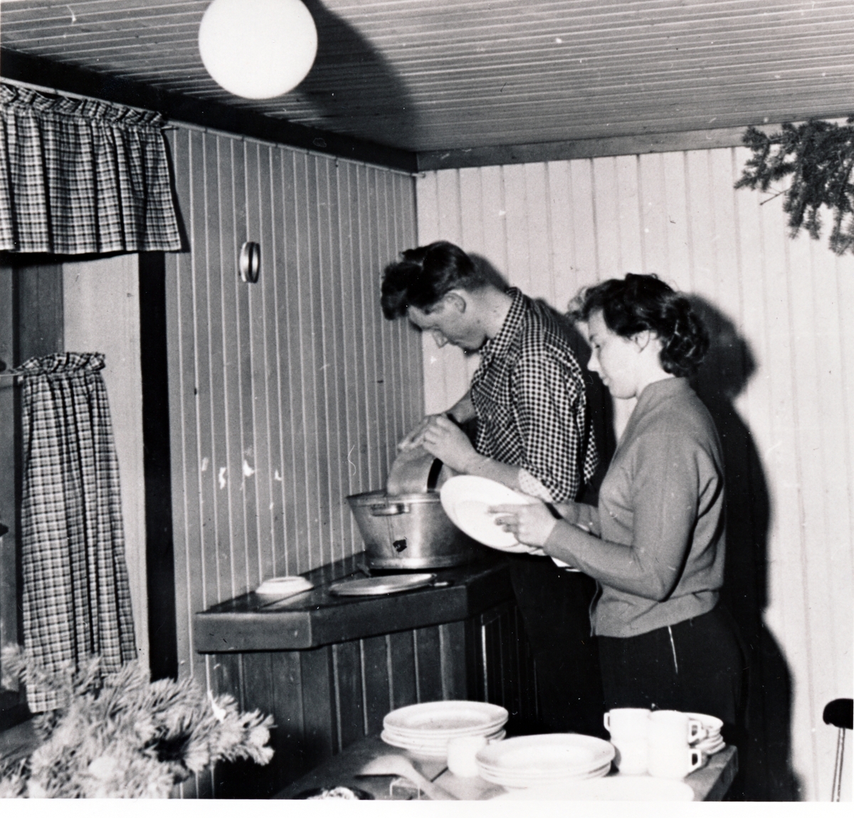 Eivind og Eldbjørg Johansen, Gryllefjord, som vasker opp på gammelmåten. 1950-1960.