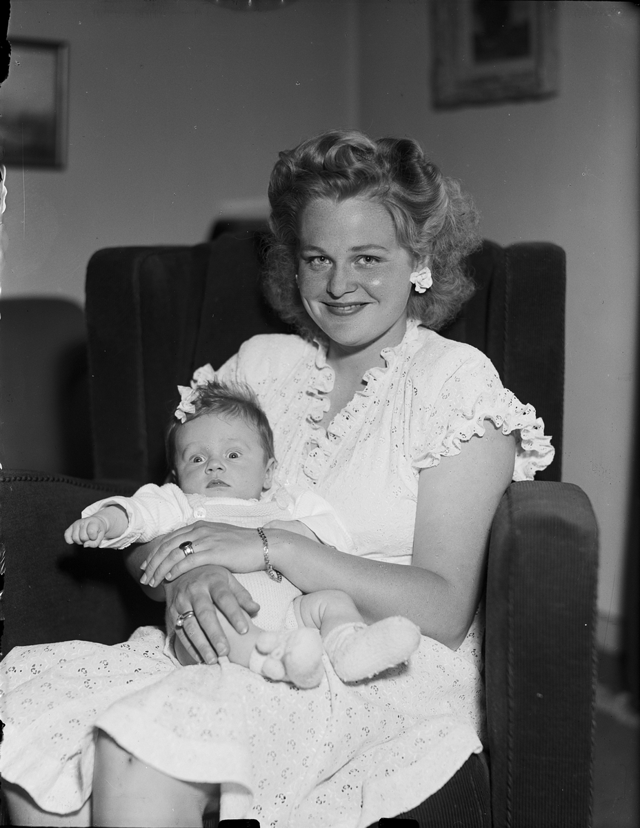 Kvinna med ett spädbarn i knät, Östhammar, Uppland