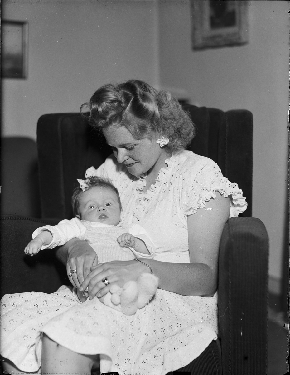 Kvinna med ett spädbarn i knät, Östhammar, Uppland