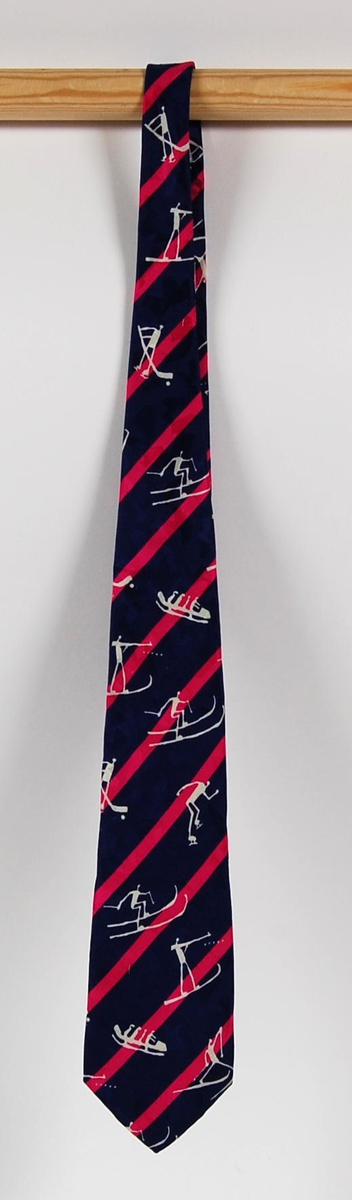 Fiolett slips med rosa skrågående tverrstriper. På slipset er det også gråhvite piktogrammer av ulike grener under de olympiske vinterleker på Lillehammer i 1994. På baksiden av slipset er det påsydd et merke med logo for de olympiske vinterleker på Lillehammer i 1994. Det er også piktogrammer på trekket på innsiden av slipset.
