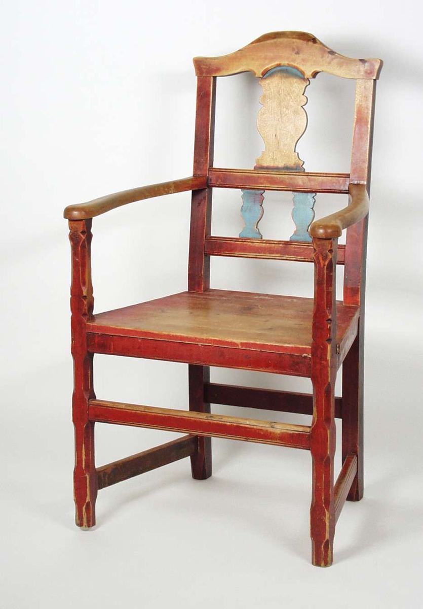 Armstol med sprosser i ryggen. Stolen er malt rød med blå sprosser. Malingen er slitt. Setetrekket er slitt i stykker i forkant. Trekket har striper i grått, rødt, blått og gult. 