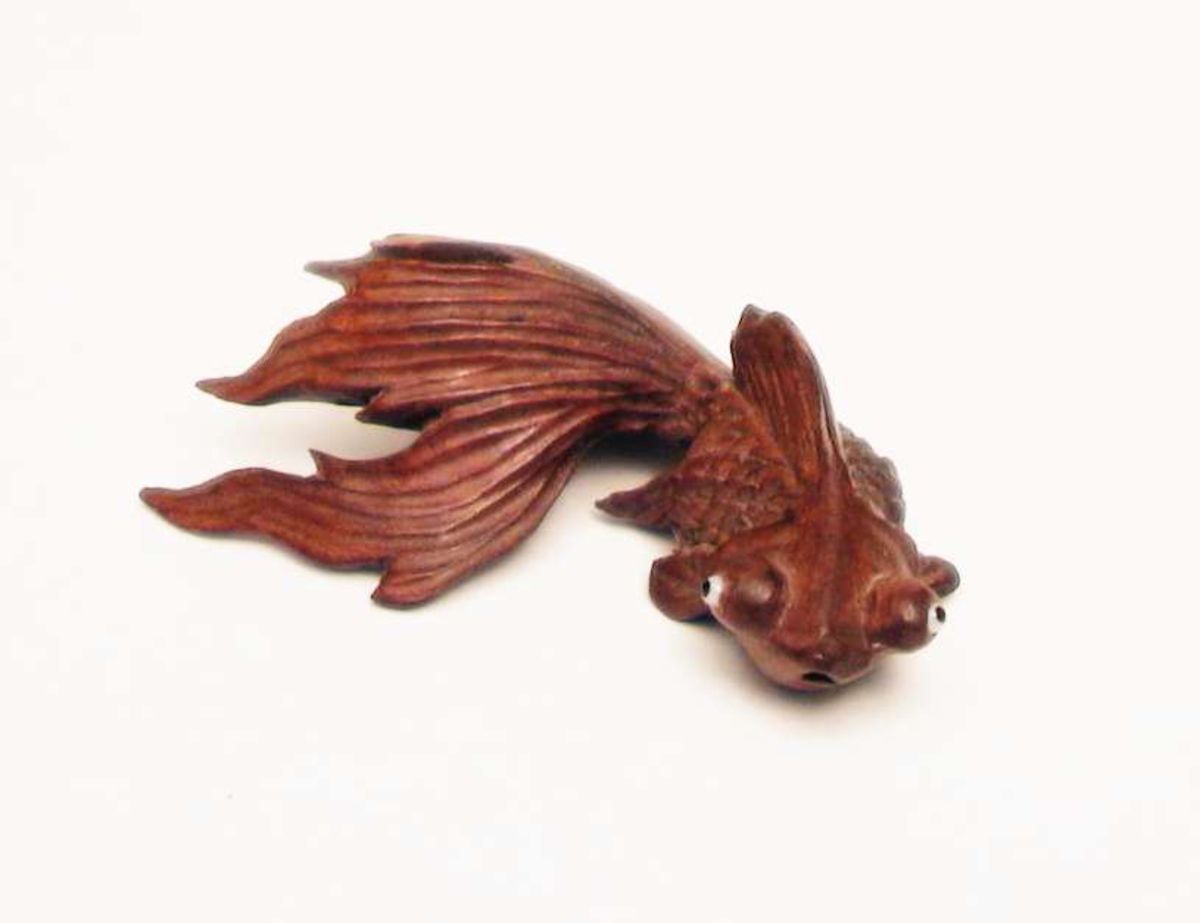 Kinesisk gullfisk utskåret i tre. Den har stor hale og utstående øyne.