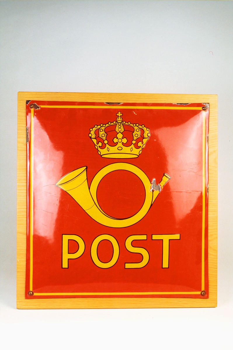 Emaljert postskilt, rød bunn med postemblem og bokstaver i gult.