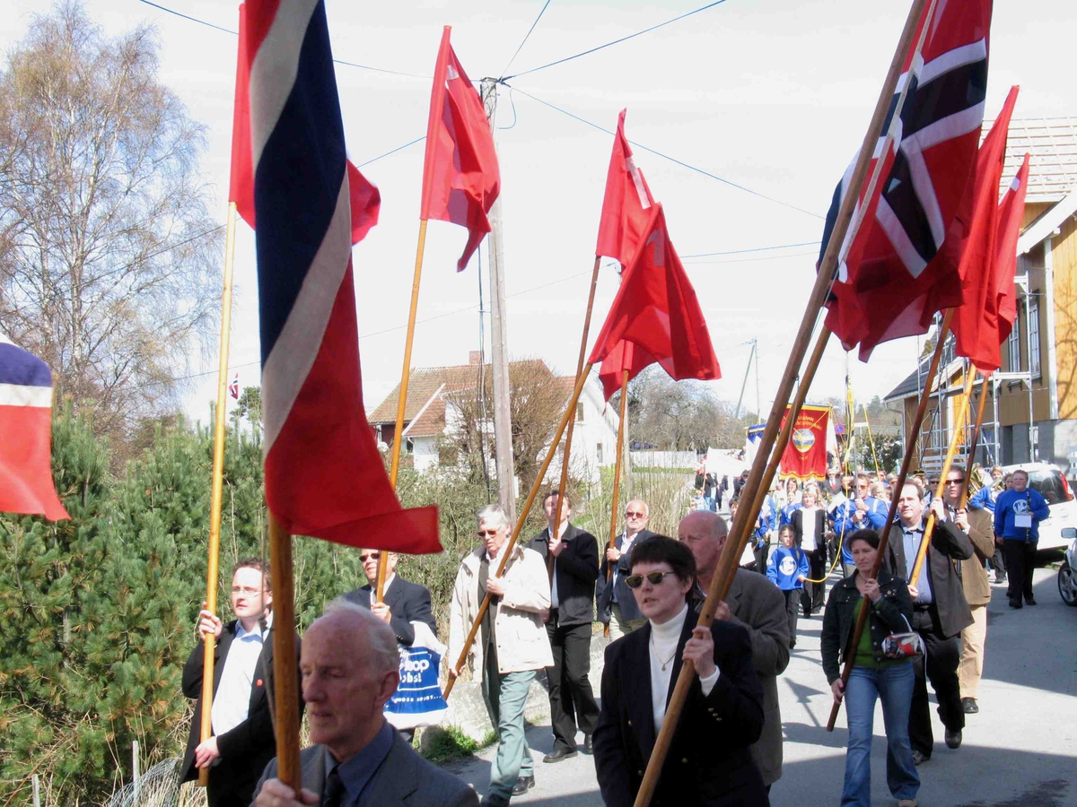 1.mai på Eydehavn. Flaggborg med norske og røde flagg. Tog fra Folkets Hus, her i  Trygve Næss`vei. 