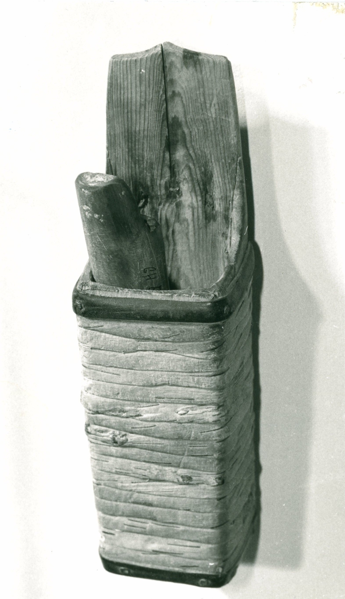 Koppen har firkantet snitt, uthulet av en stokk. Bakre kant stikker opp. På baksiden er en flat jernplate med tilbøyd krok.