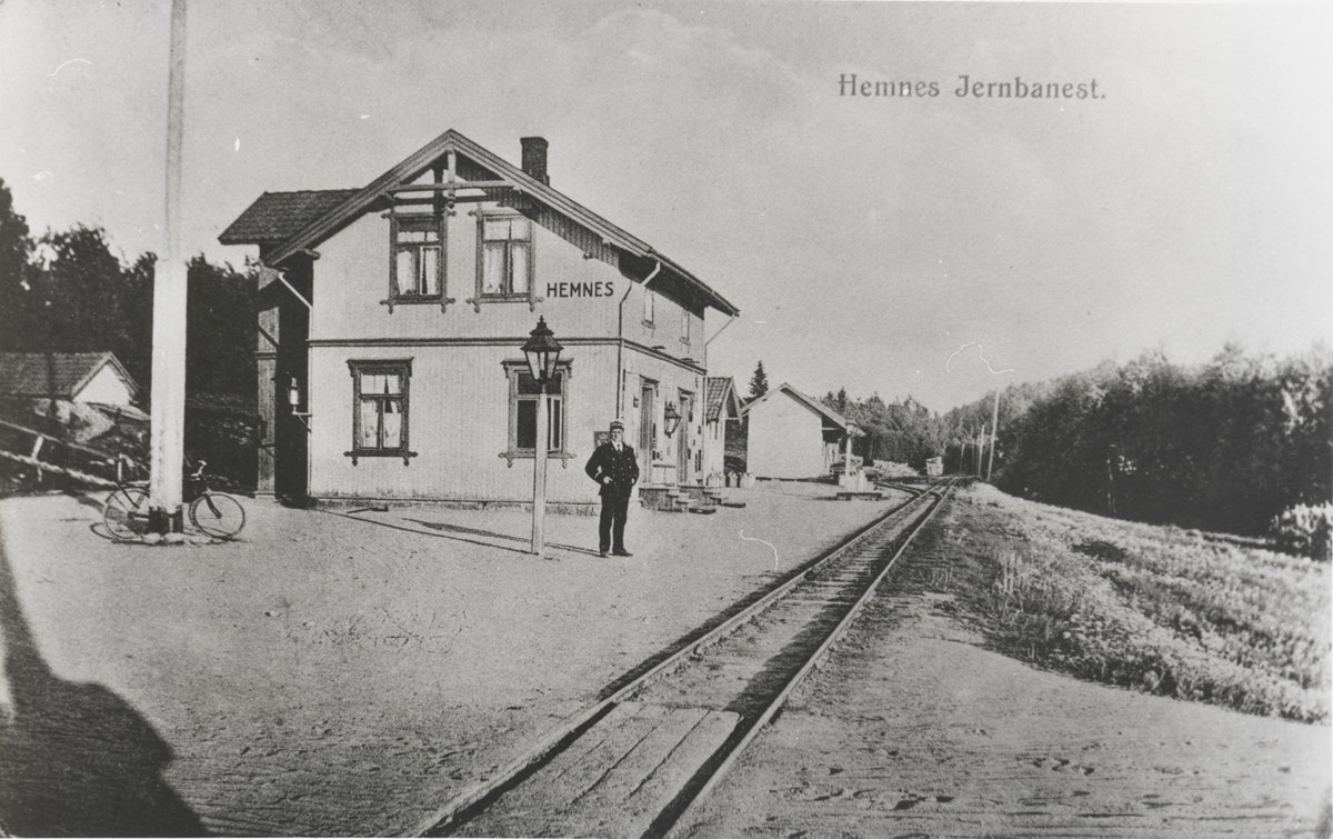 Hemnes stasjon. Stasjonsmesteren poserer foran stasjonen.