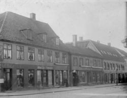 Gatemiljø med butikker. Johan Lie, Uhrmager, Storgata 16. St