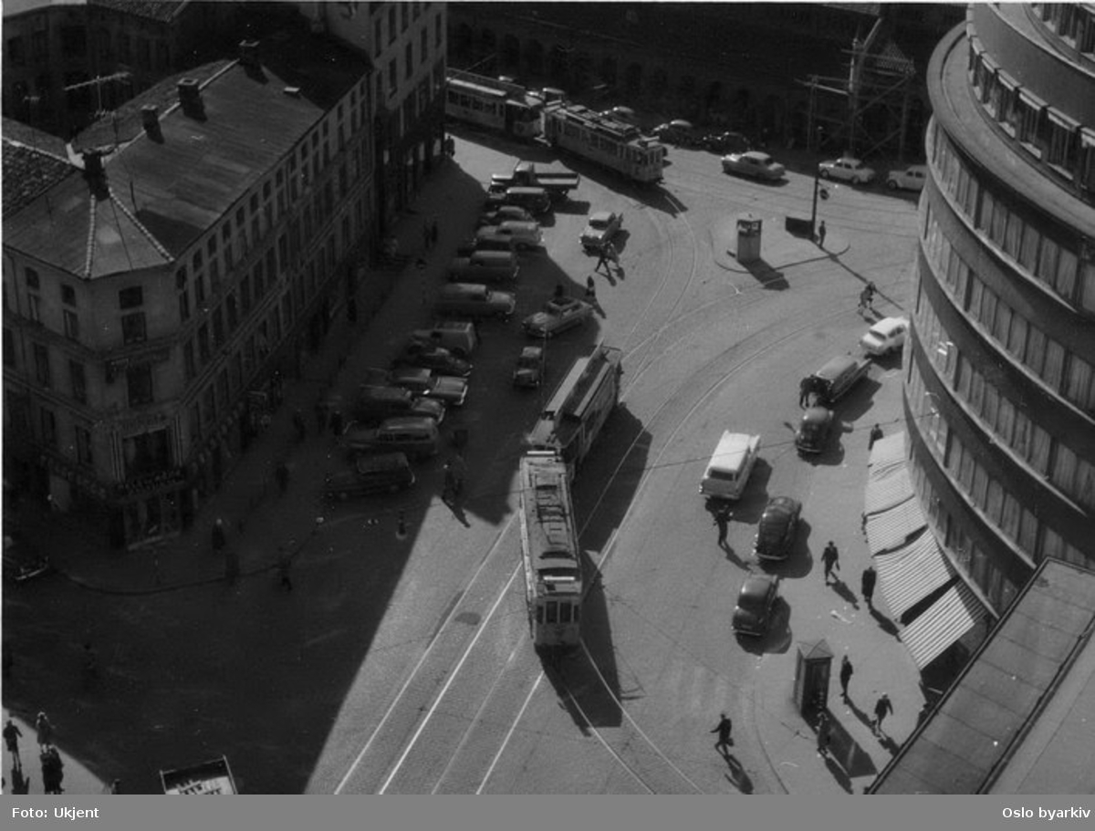 Oslo Sporveier. Trikk motorvogn 103 type SS lang med tilhenger svinger inn i Skippergata fra Gunnerus' gate. Gatebilde, bilparkering.