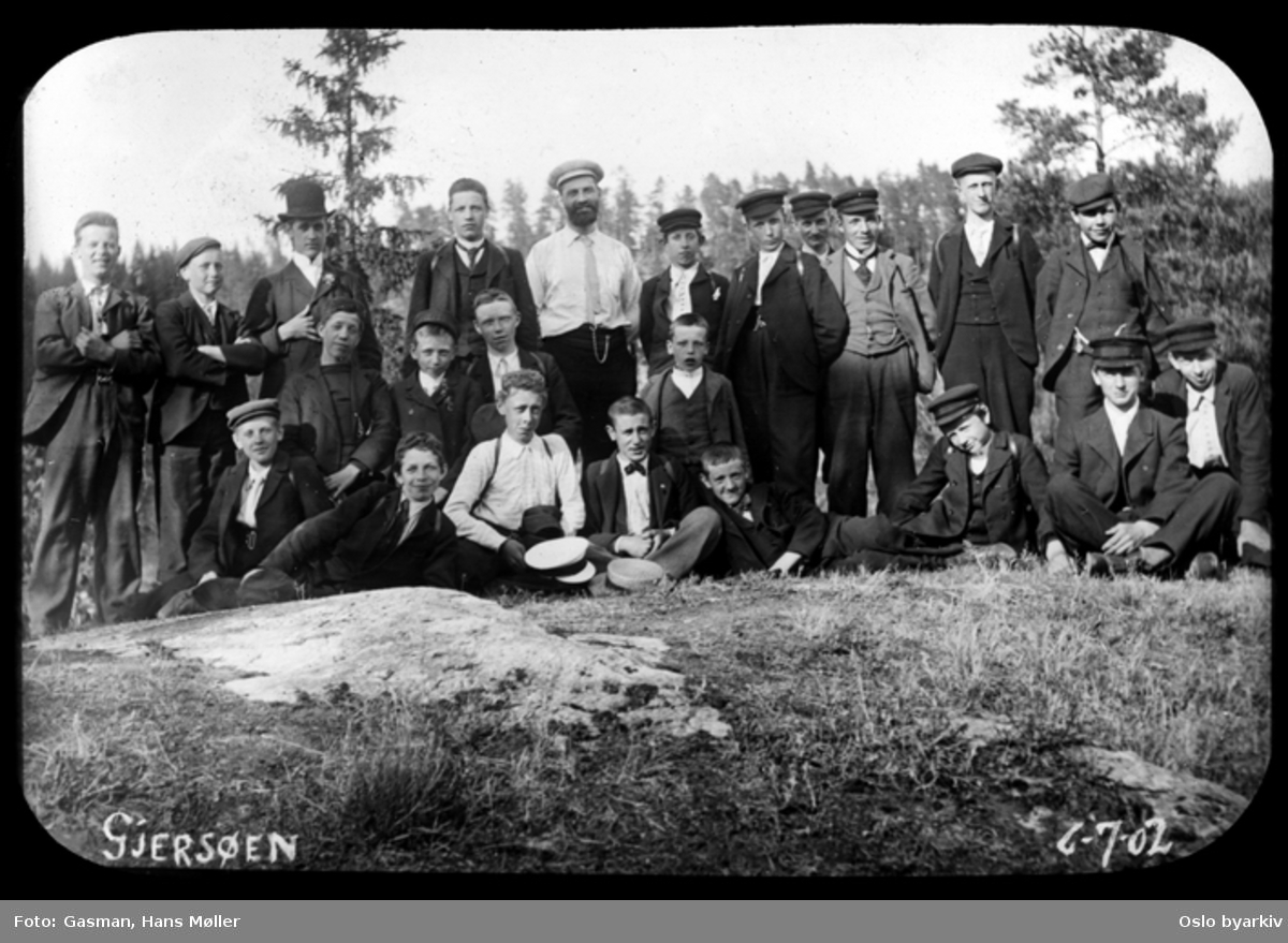En gruppe menn og ungdommer poserer for fotografen ved Gjersjøen i Oppegård, 6. juli 1902