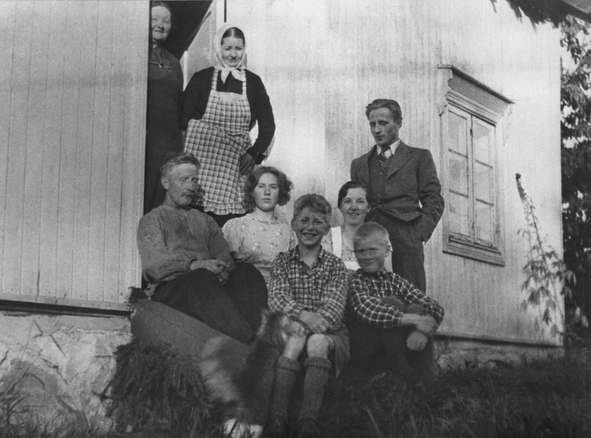 Familie i Stensby, Stavsjø, Hedmark. Andor Stensby (1886-1976), Agnethe f.1883 med rutet forkle. Tante i døra. Adolf Brattengen i dress. Barna er Signe f.1910, Mary f.1920, Harald f.1912, Paul f.1922.