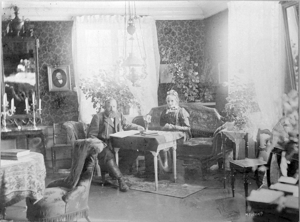 Interiør storstua på Hoel gård, Nes, Hedmark. Karl Kildal (gamle Karl 1854-1915) med sin mor Marie Gotaas Kildal 1817-1900).