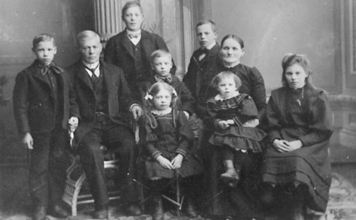 GRUPPE: 9, FAMILIEN SKÅRÅSBERGET, FRA VENSTRE: SYVERIN, FAREN OLE, NILS, OSKAR, OLAF, PERNILLE, NORA, MATILDE, PETRA, VALLSET I STANGE. 
De to elste døtrene Anna og Ingeborg er ikke med på bildet, de reiste til USA i 1903