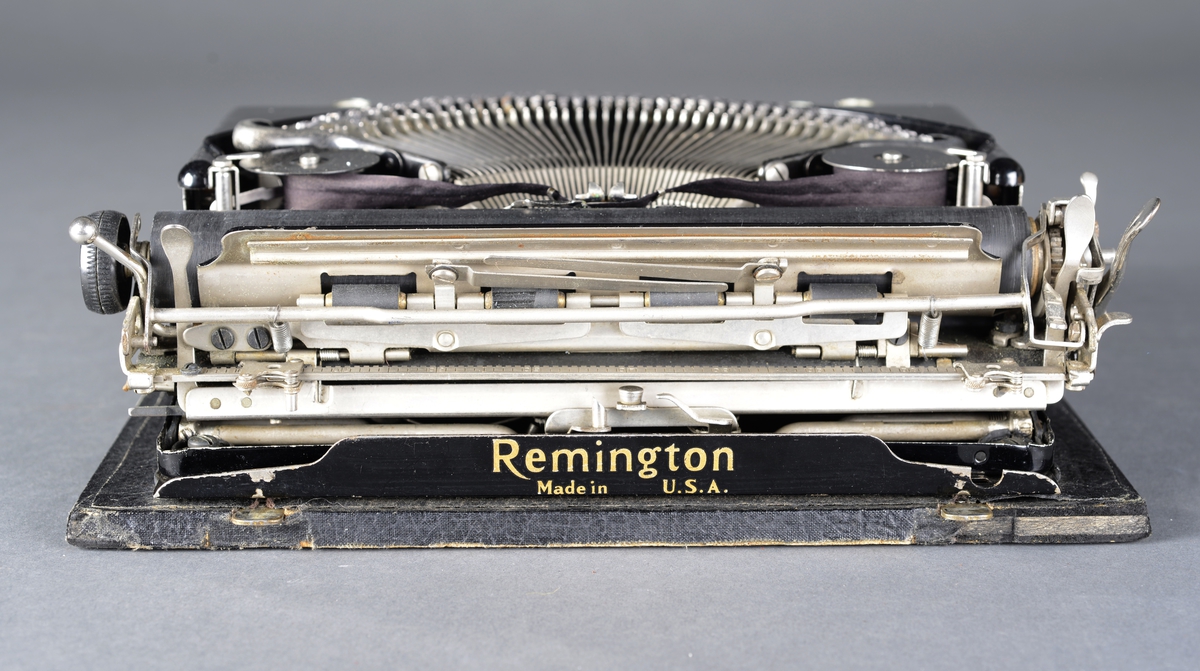 Bærbar skrivemaskin med qwerty-tastatur i koffert, avtagbart lokk.