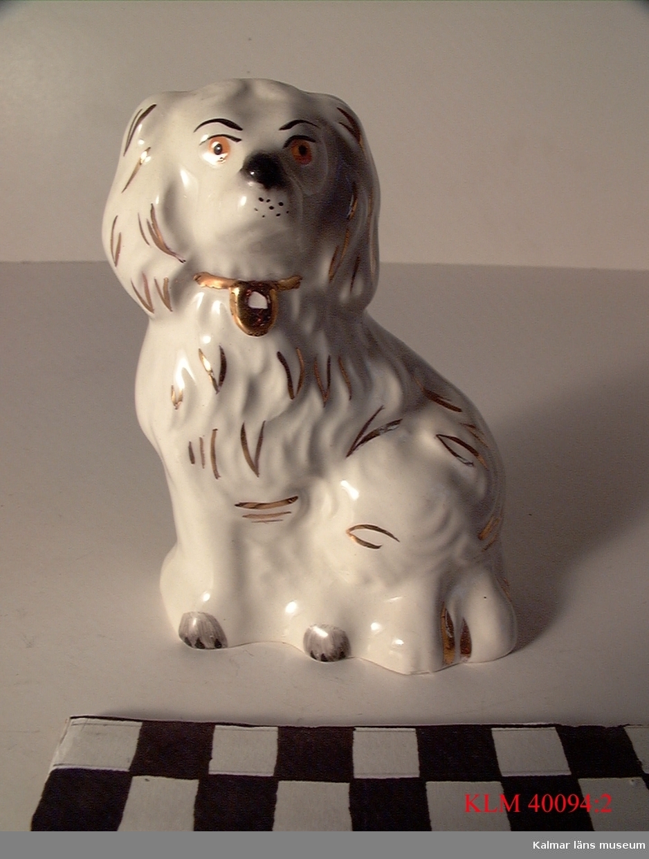 KLM 40094:2 Figur, porslin. Föreställer en hund, vit med detaljer i guldfärg. Stämpel: Beswick, England 1373.