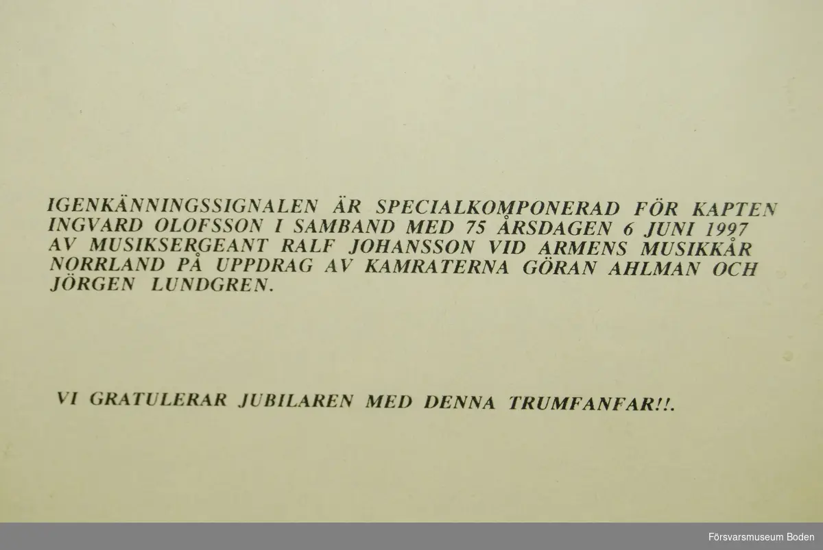 Glasad tavla med noter till igenkänningsignal för kapten Ingvard Olofsson i samband med dennes 75-årsdag 6 juni 1997. Signalen är komponerad av musiksergeant Ralf Johansson vid Arméns musikkår Norrland.