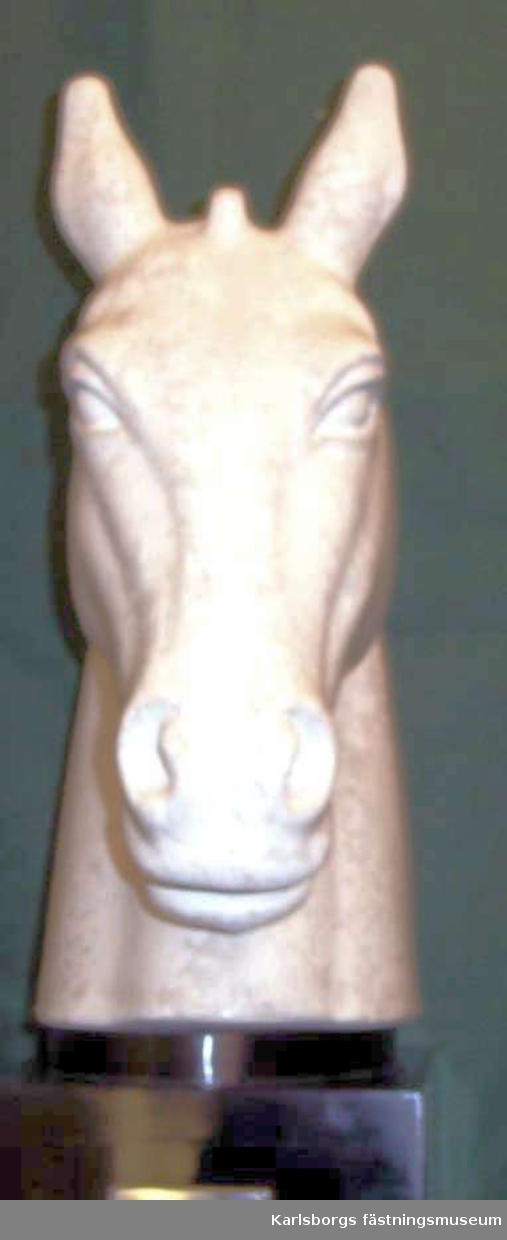 Hästhuvud på svart träsockel med inskriptionen Rörstrands hederspris i Nordiska ryttarspelen Skövde 1957. Hästhuvudet i keramik med marmorerad glasyr. Märkt Rörstrand G. Nylund Unik