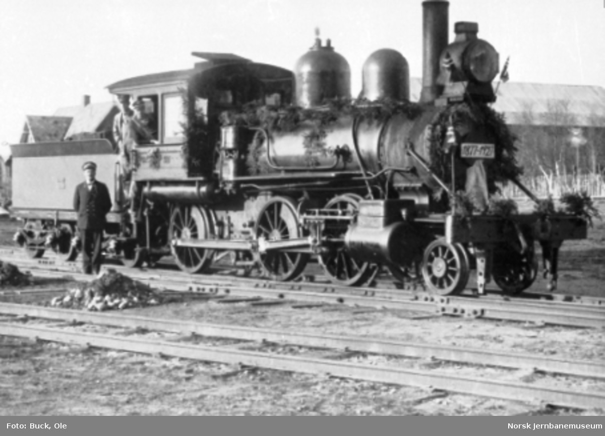 En pyntet damplokomotiv type XVIb nr. 37 med personalet på Røros på banens 50 års-dag