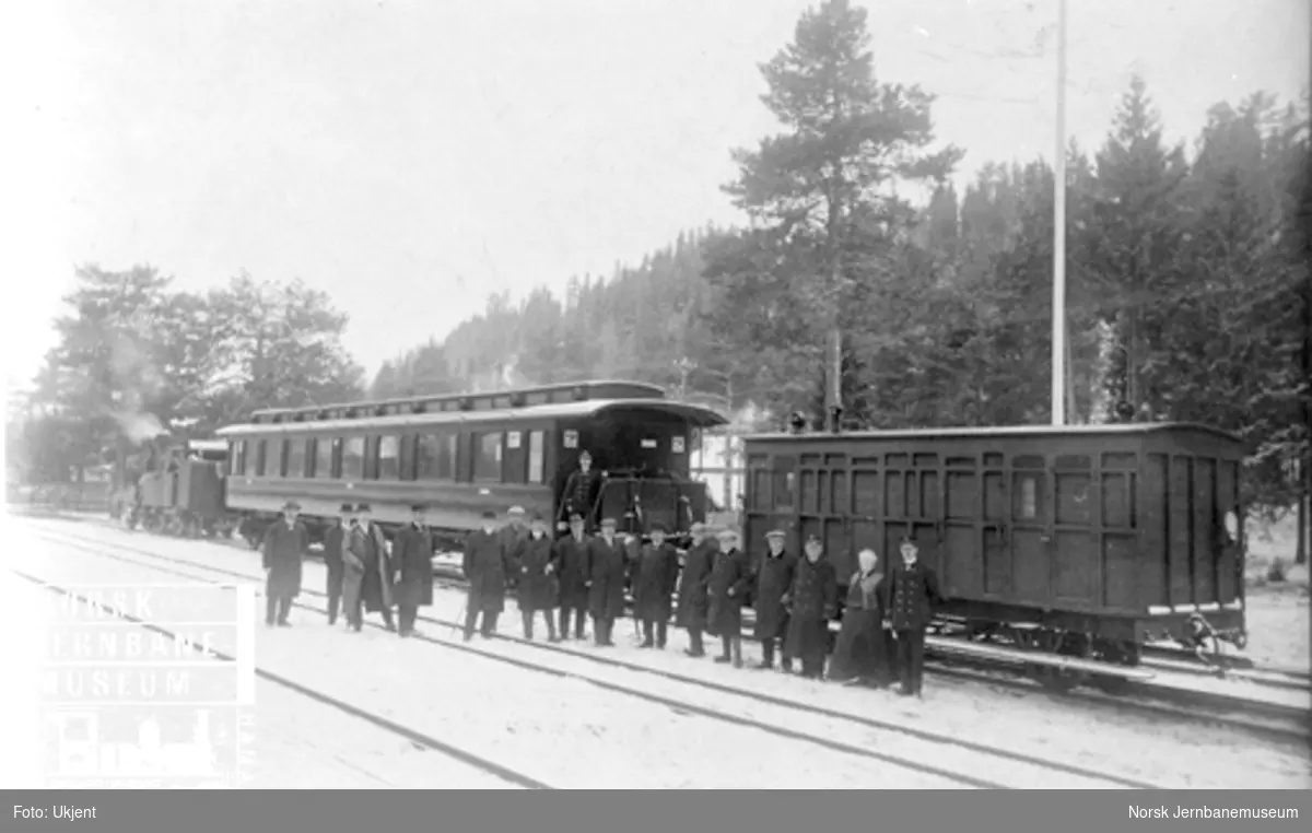 Åpningstoget for treskinnesporet Elverum-Rena, bestående av damplokomotiv type VII, en normalsporet personvogn og en smalsporet karet og deltakerne oppstilt for fotografering