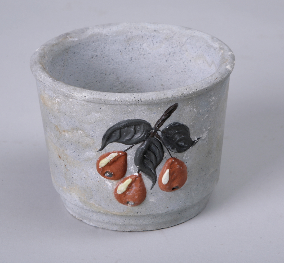 Sylinderformet potte til å sette blomsterpotter i. Dekorert med påmalte blader og bær.