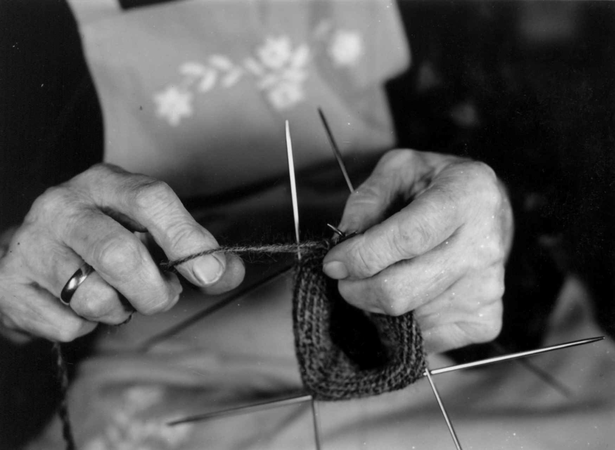 "Tveband". Fru Ramstad demonstrerer strikking av toband på utstilling i Nannestad juni 1958. Akershus.