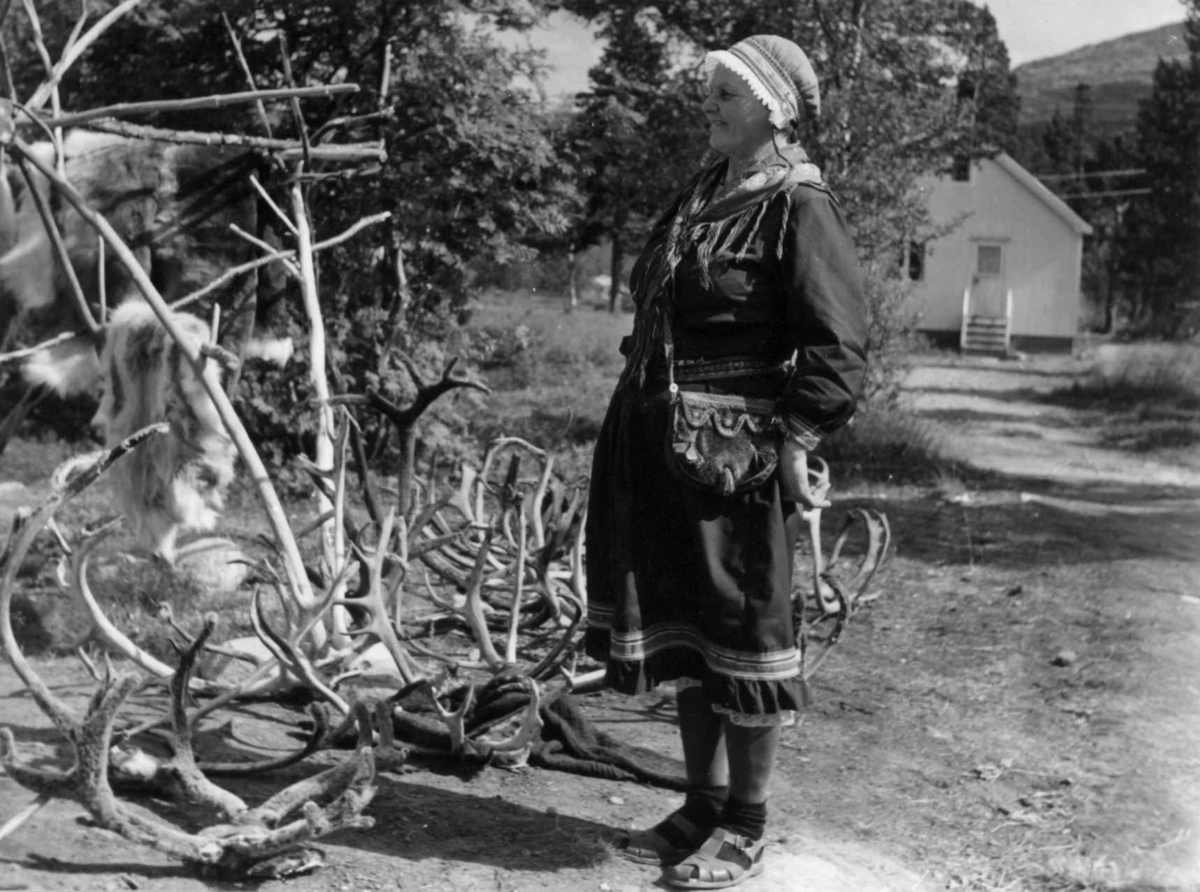 Ella Blind ved sitt souvenirutsalg med reinsdyrhorn og reinsdyrskinn. Lønsdal 1964.