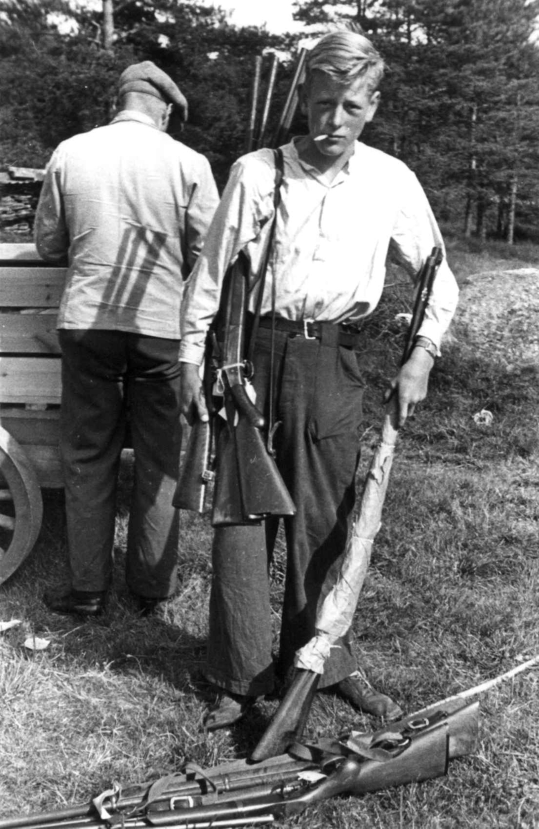 To menn med en samling våpen ute ved en vogn. Frostemyr 1941.