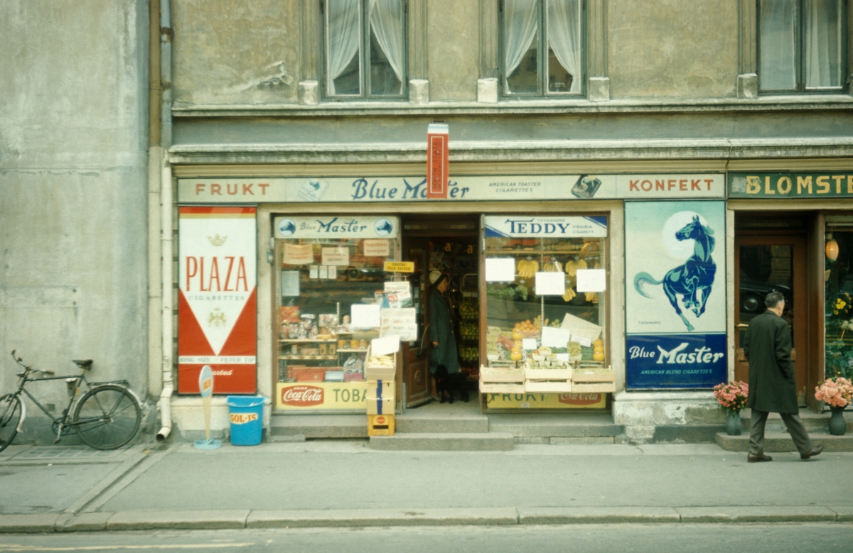 Gatebilde. Butikklokale med reklame for tobakk. Blue Master og Plaza sigaretter.