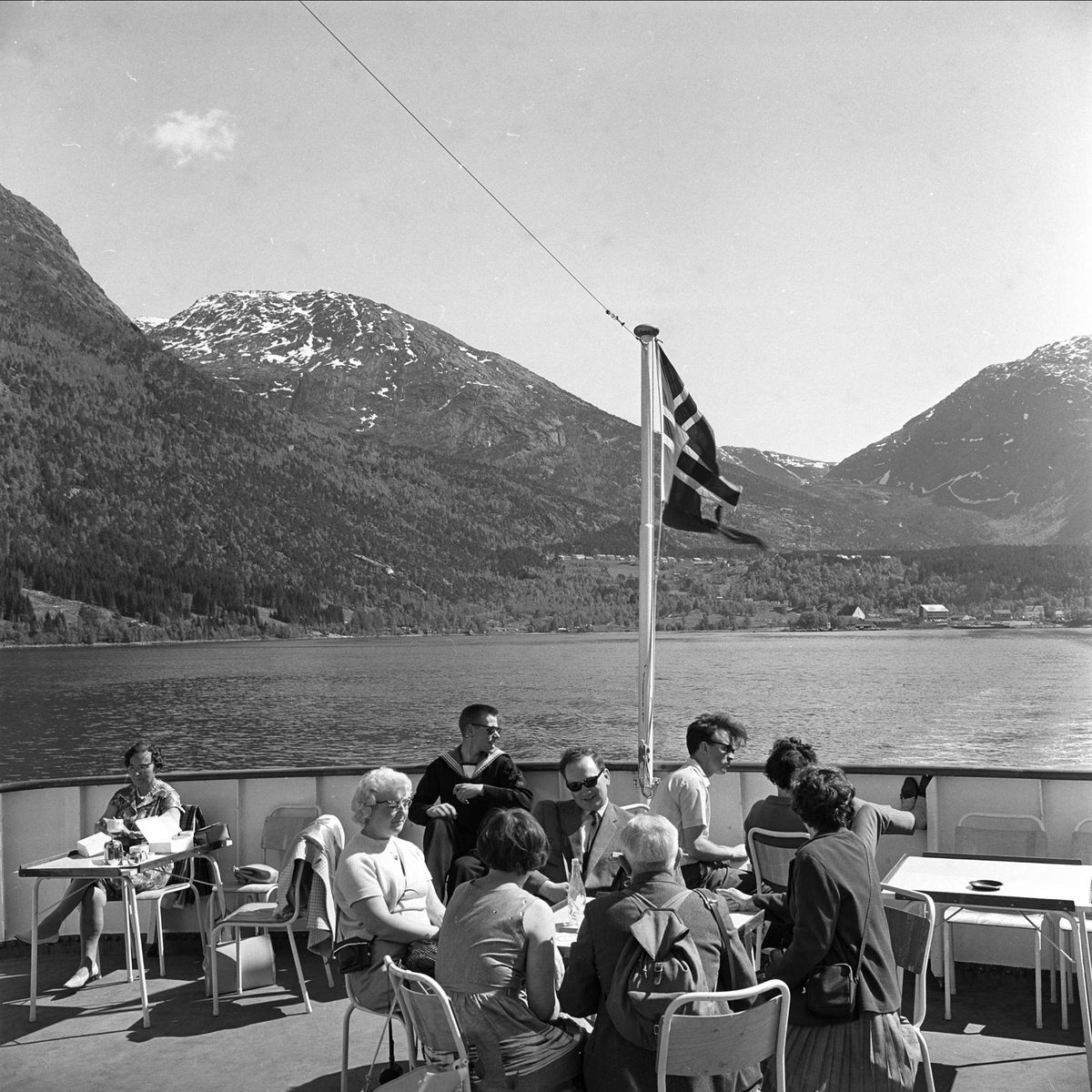 Sørfjorden i Hardanger, Hordaland, mai 1963. Folk sitter på båtdekk.