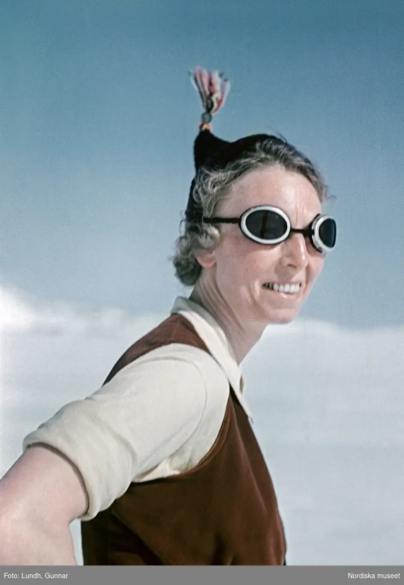 Porträtt av kvinna i skidglasögon och toppluva i solen.