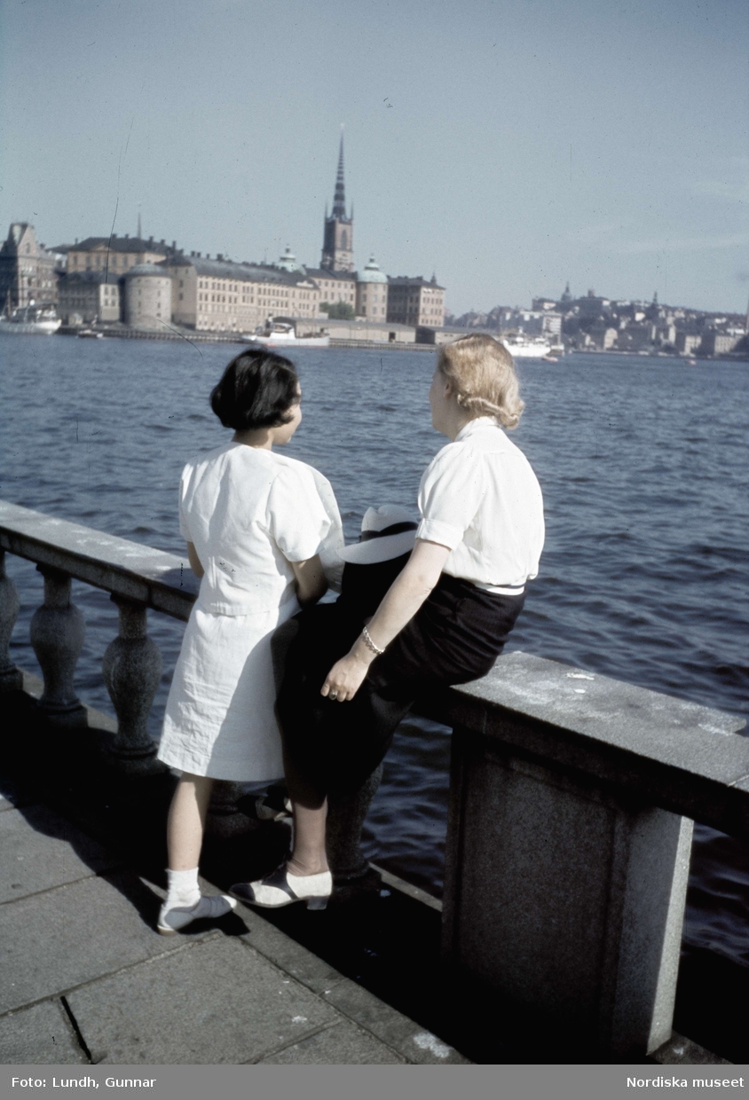 Stockholm. Två kvinnor tittar ut över Riddarfjärden från terass vid Stadshuset.