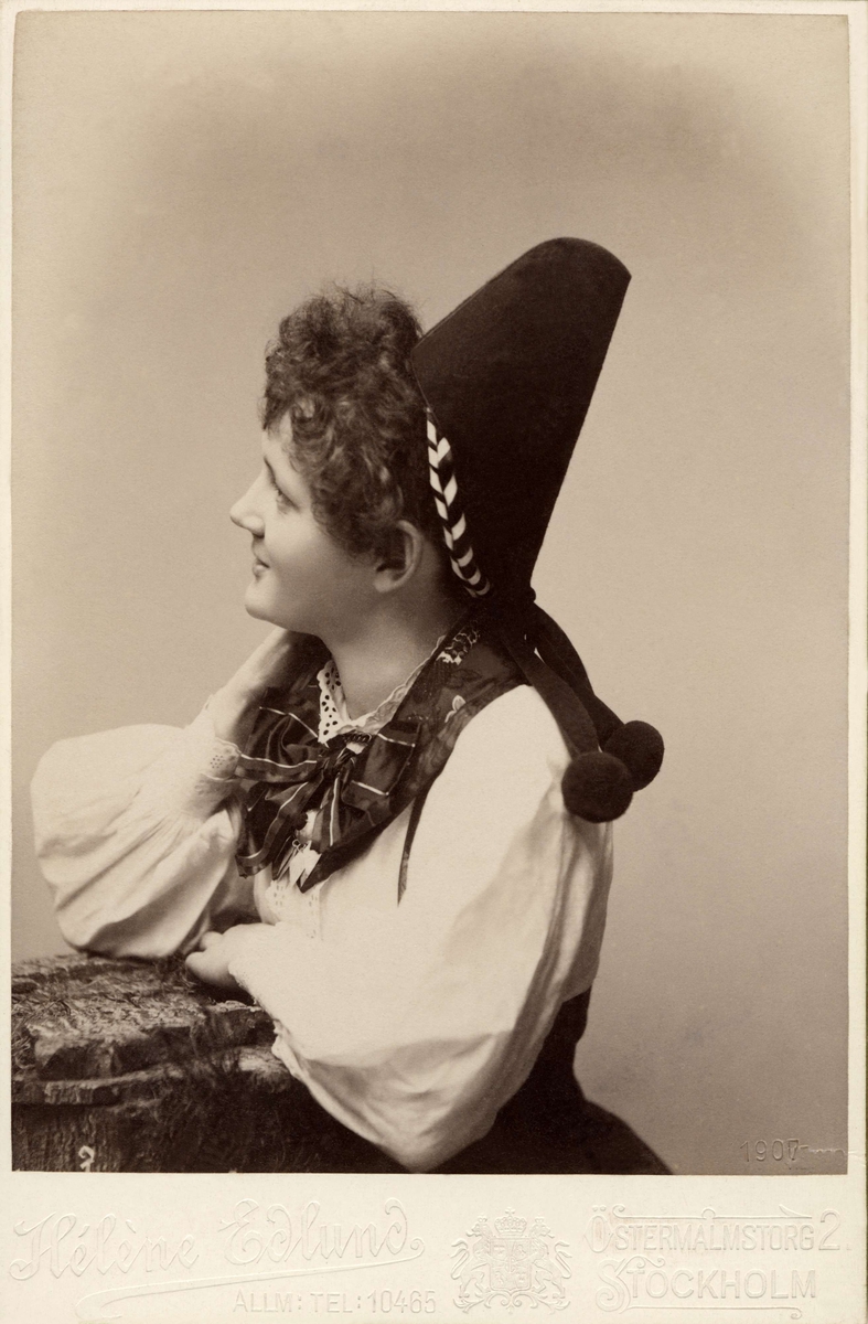 Porträtt på en kvinna klädd i dräkt från Rättvik i utförande från omkring 1900.