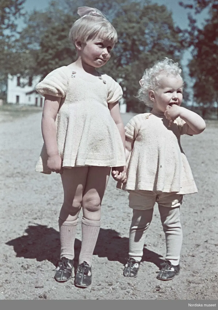 Två flickor i stickade klänningar.