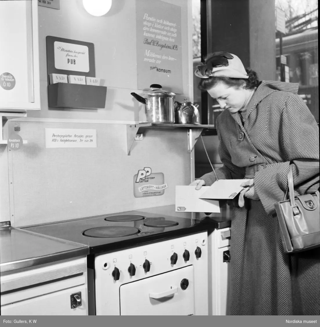 Affärsinteriör. Kvinna i köksmiljö jämför prov på plastlaminat, så kallad perstorpsplatta.