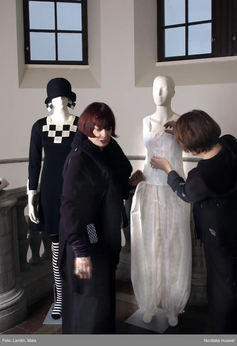 Gunilla Pontén (t v) och intendent Ingrid Roos provklär dockorna inför Gunilla pontén-utställningen på Nordiska museet 2004. Mannekängen till vänster är en klänning från 1960-talet, till höger en 1980-talskreation.
