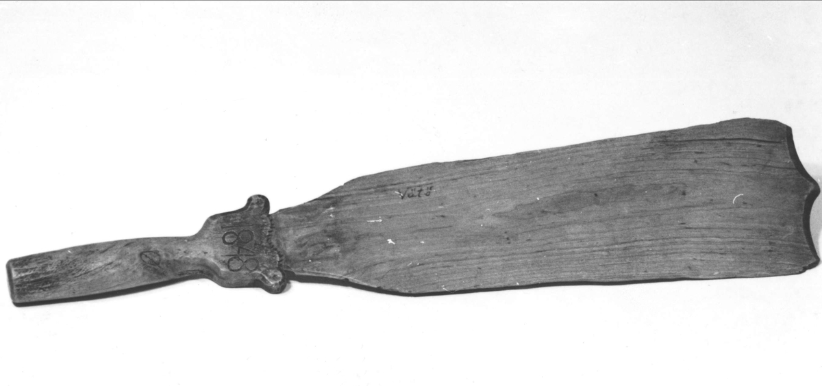 Skäktkniv av trä. Dekor i uddsnitt. På ena sidan inristat: 1848, på andra en geometrisk figur. Påskrivet med bläck: Vätö.