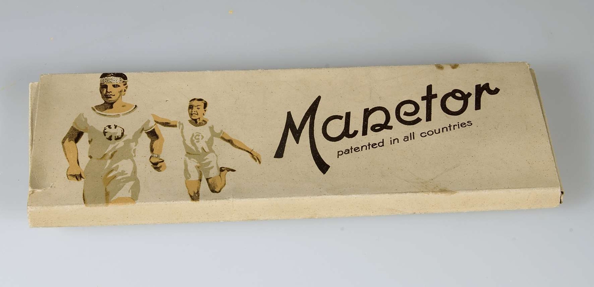 Vit med dekor i vitt och brunt. Text "Manetor patented in all countries". Innehåller ett pannband av perforerade runda gipsplattor. Fästes runt huvudet med bomullsband.


