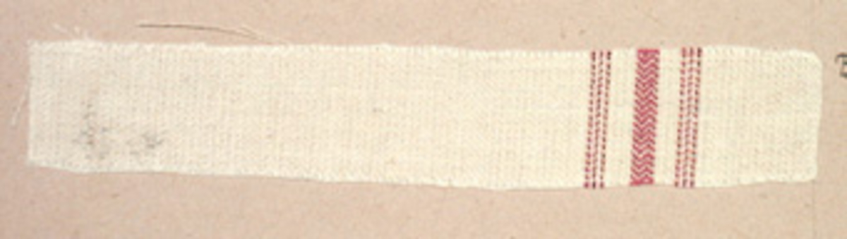 Vävprov ämnat för handduksväv, vävt med bomulls- och lingarn, vitt med ränder i rött. Vävprovet har nummer "B-394".