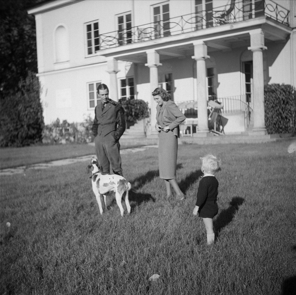 Kungliga Vattenfallsstyrelsen - familj med hund ute i trädgården, sommar 1937