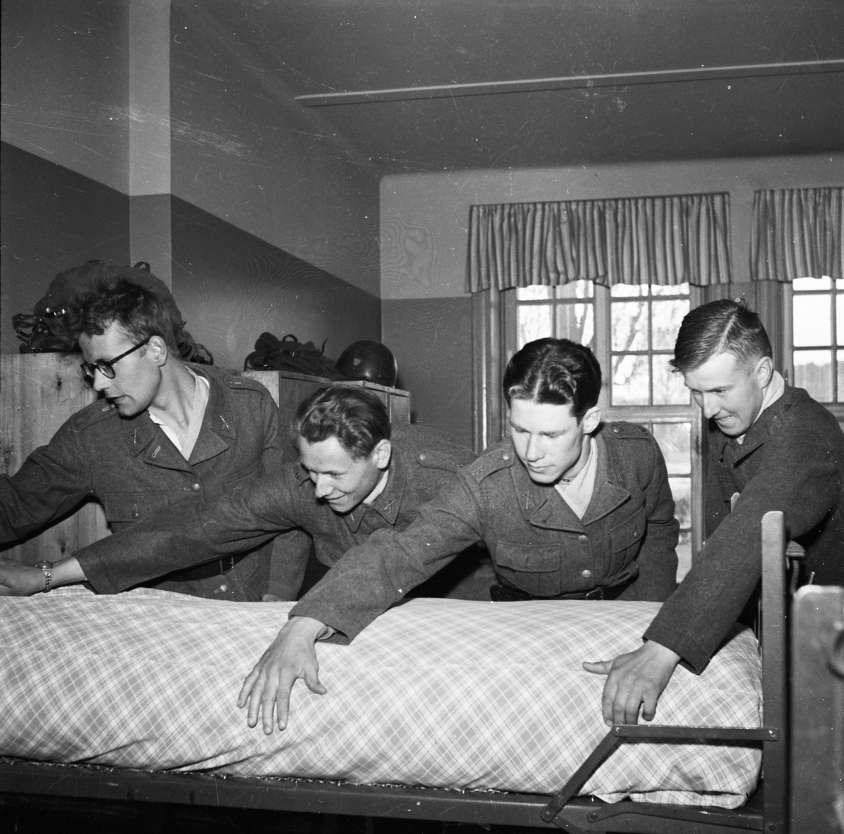 "Ny rekrytomgång på I 8" - Upplands regemente, Uppsala maj 1952. Lars Bertil Bertilsson, Bert Lötstedt, Emil Stenros och Reidar Hagström bäddar säng