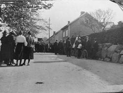 Norestraen ca. 1920: mange mennesker på en gate.

Supplerand