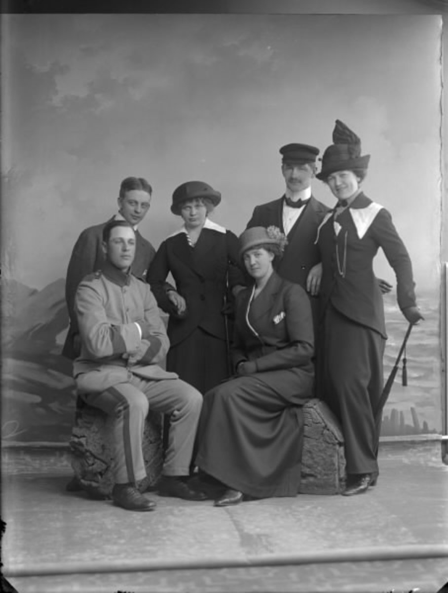 Gruppbild av män och kvinnor i hattar, ateljéfoto