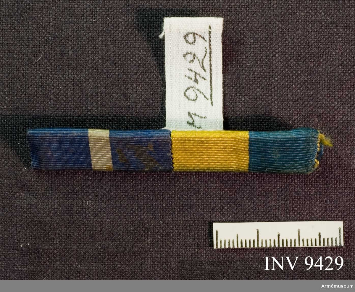 Ordensbanden är två stycken.
Nr ett har färgerna blått, vitt och blått. Nr två har färgerna gult och blått. På baksidan ett broschspänne.