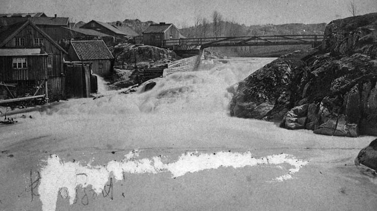 Enligt text på fotot: "Vattenfallet och qvarnen vid Strömberget Uddevalla, med spången före branden 1886 taget 1867. Nils fädernehem".