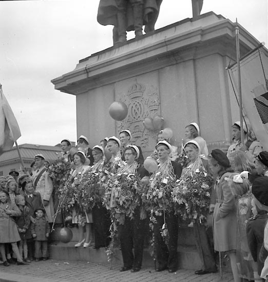Studentexamen i Uddevalla 22 maj 1948. Glada studenter framför statyn på Kungstorget av kung Karl X Gustav och hans rådgivare Erik Dahlbergh.