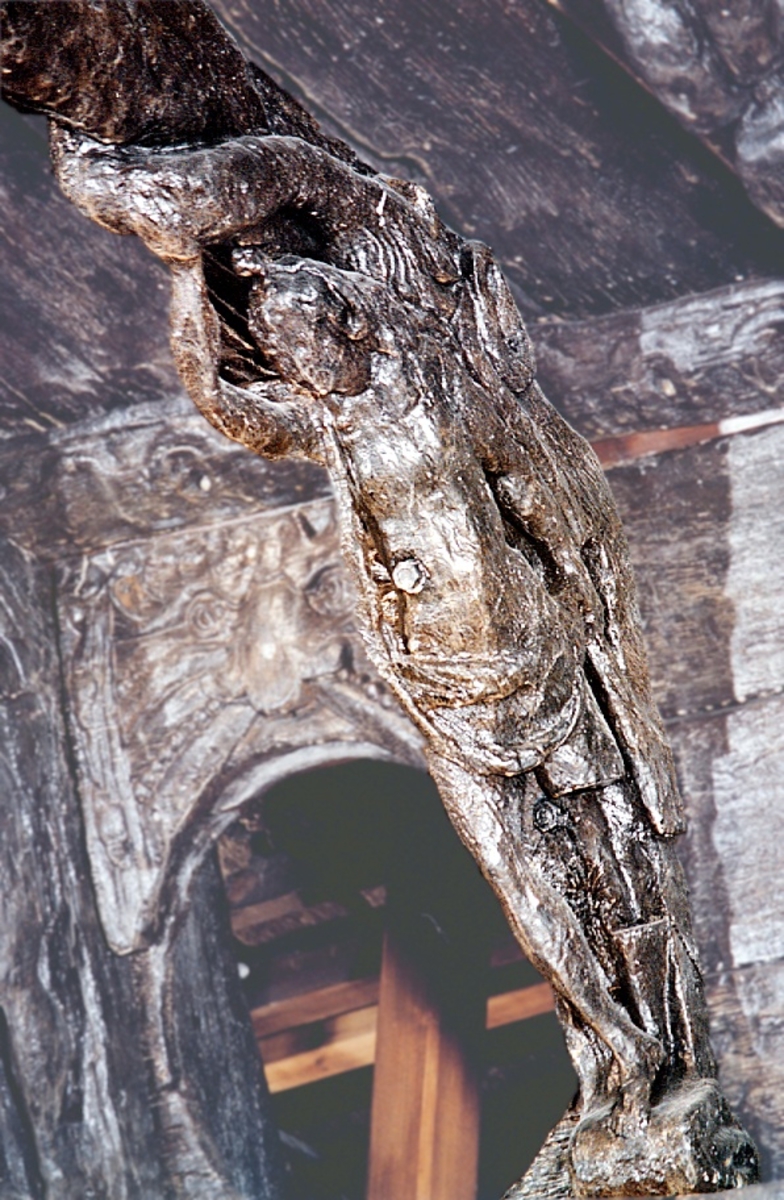 Lång och smal skulptur med den övre delen utformad som en triton och den undre som en karyatid.
Kvinnofiguren är stående på sockel, iförd löst draperad klädnad som hon skyler sig med med hjälp av vänster hand. Högra armen är kraftigt bakåtböjd och handen griper tag i tritonen upptill, vars tudelade, upprullade stjärt bildar en vulst ovanför kvinnans huvud.
Tritonens huvud har ett flikigt skägg och vingliknande utskott i axelhöjd. Ellipsformad volut sitter på ömse sidor av sockeln. Broskbildningar finns på varje sida av skulpturens vinkel. Spikskallar på framsidan.
Skulpturen utgörs av en konsol med slät bak- eller undersida och böjd i vinkel. Vinkeln är på baksidan markerad genom ett halvrunt urtag, 200-250 mm i diameter. Det övre vinkelbenet är nästan dubbelt så långt som det nedre.
Tritonen är sämre bevarad än den kvinnliga figuren.

Text in English: Long and slender sculpture with the upper section shaped as a Triton and the lower as a Caryatid.
The female figure stands on a base and is clad in a heavily pleated garment, worn from her head and down her flat back. The female figure is partially placed in front of the Triton which forms the console''s upper-side angle. The woman has her gown or dress loosely draped over her right shoulder and it therefore falls down her back. Her left hand holds the drape in place. Her right arm is held up towards the Triton whose divided fish tail forms a torus above her head.
The Triton''s head has a segmented beard and  wing-like protuberances at shoulder height. There are elliptical volutes on either side of the base.
The sculpture consists of a console with flat back or reverse and is curved at an angle. The angle is marked on the reverse side by a semi-circular recess, 200-250 mm in diameter. The upper side of the angle is almost twice as long as the lower side. Earshell work on the sculpture''s side angles.
The Triton is less well-preserved than the female figure.