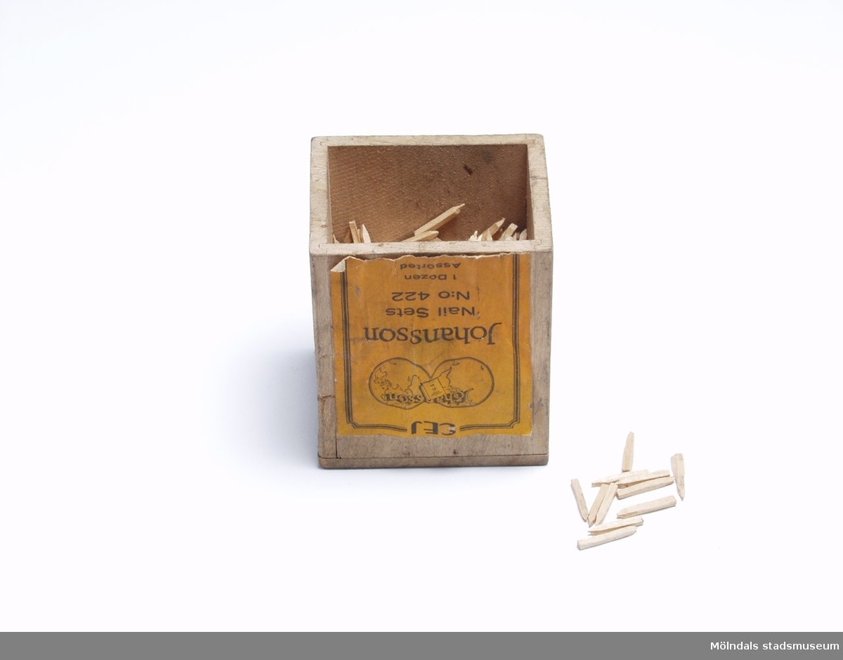En träförpackning med skopligg. Gul etikett "Johansson, Nail Sets N:o 422, 1 dozen, Assorted".