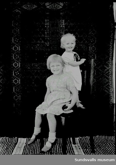 Porträtt. Två barn på en stol.