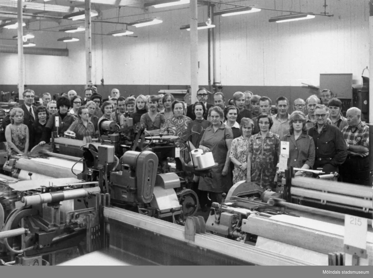 Arbetare vid Krokslätts fabriker i Mölndal år 1971.
Text på bildens baksida: "Sista metern väv (nylontaft) slutvävdes fredag 10 dec 1971 kl 10.48 av Linnea Dahlryd".