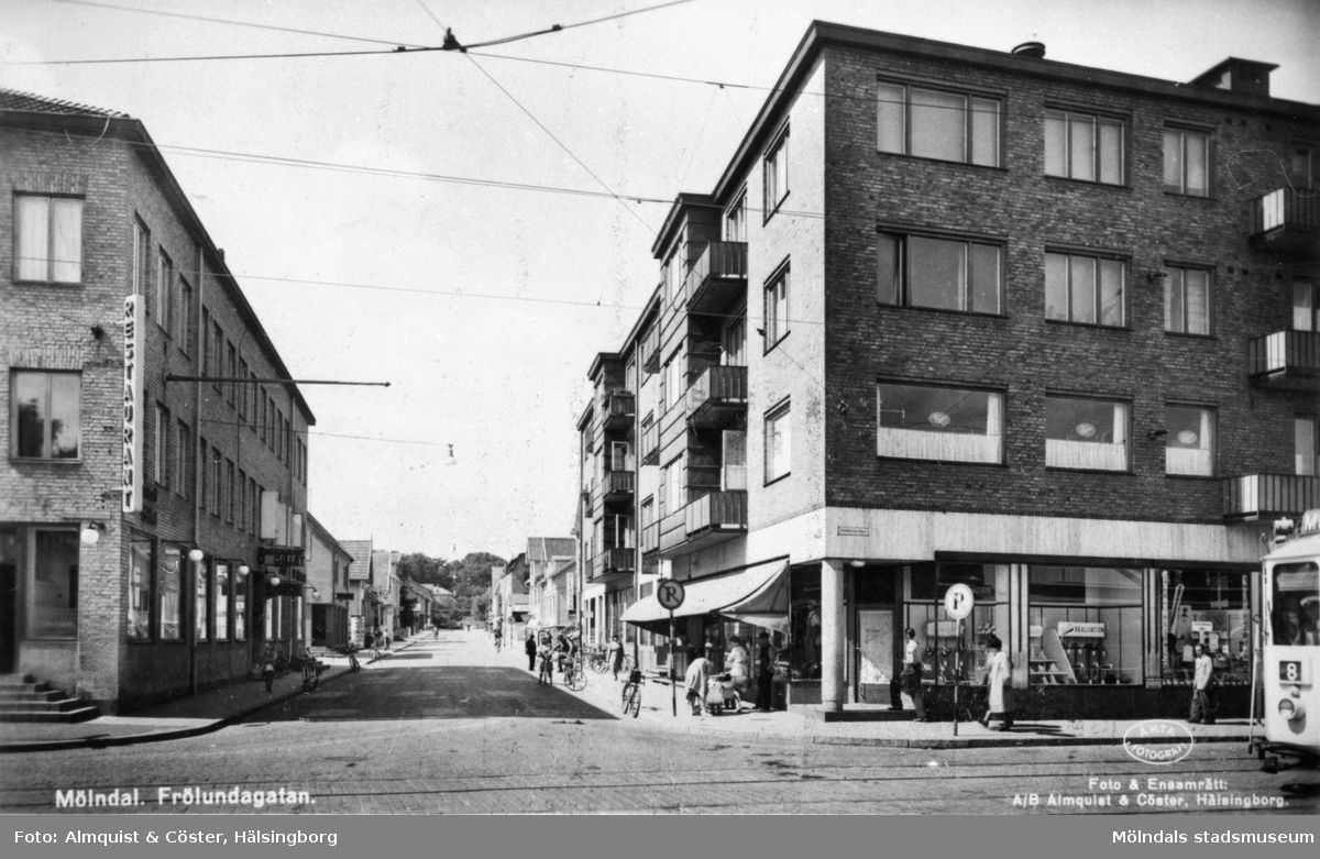 Vykort "Mölndal. Frölundagatan" med vy från Göteborgsvägen-Kungsbackavägen, 1940-tal. Till vänster skymtar "Gillet" (i Hantverkshuset på Frölundagatan 1/Kungsbackavägen 2). Till höger ses Centrumhuset (Göteborgsvägen 1-5).