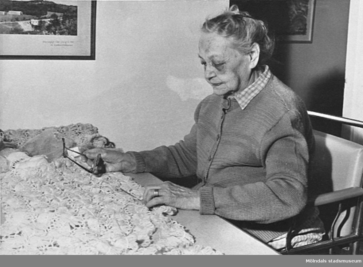 En kvinna sitter vid ett bord med garn i arbetsterapin på Lackarebäckshemmet, okänt årtal.